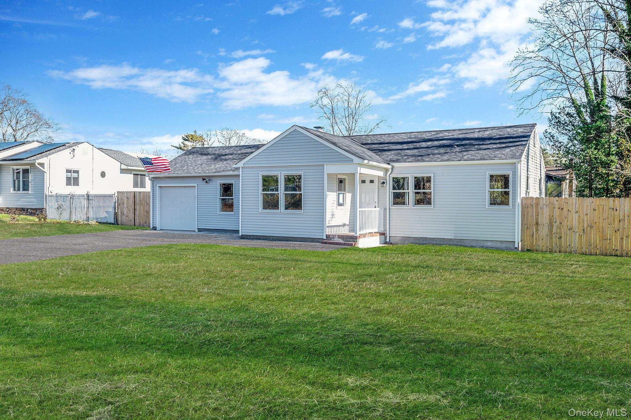 View of front facade with asphalt driveway, roof with shingles, and an attached garage
