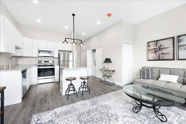a living room with furniture a dining table and a chandelier