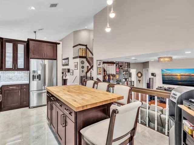 a living room with stainless steel appliances kitchen island granite countertop furniture wooden floor and a kitchen view