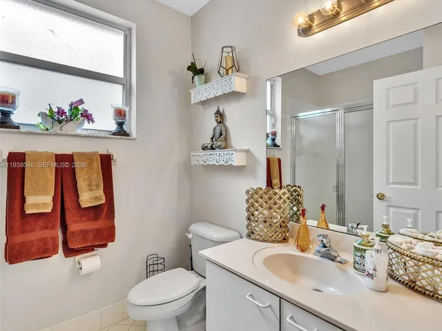 a bathroom with a sink mirror and toilet