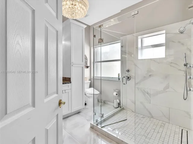 a bathroom with a glass shower door and a window