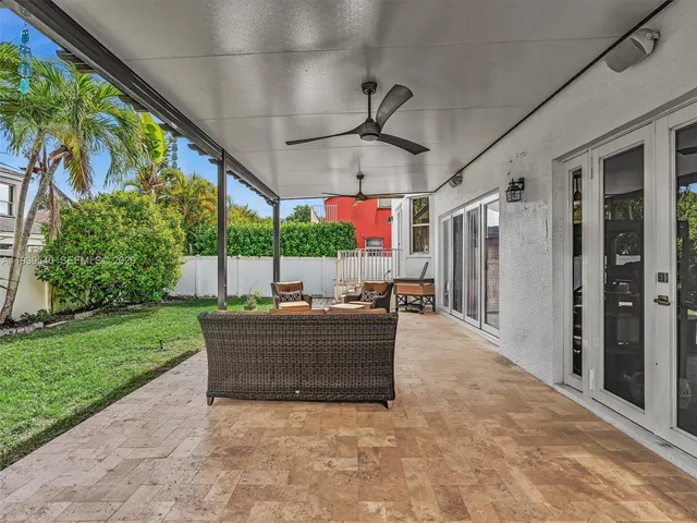 a view of a patio with a table and chairs under an umbrella