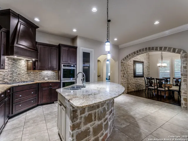 a kitchen with kitchen island granite countertop a table and chairs in it