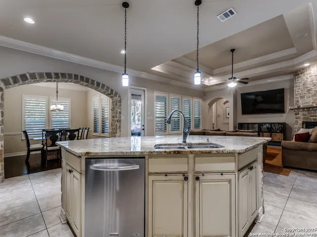 a kitchen with stainless steel appliances granite countertop a sink a stove and a wooden floors
