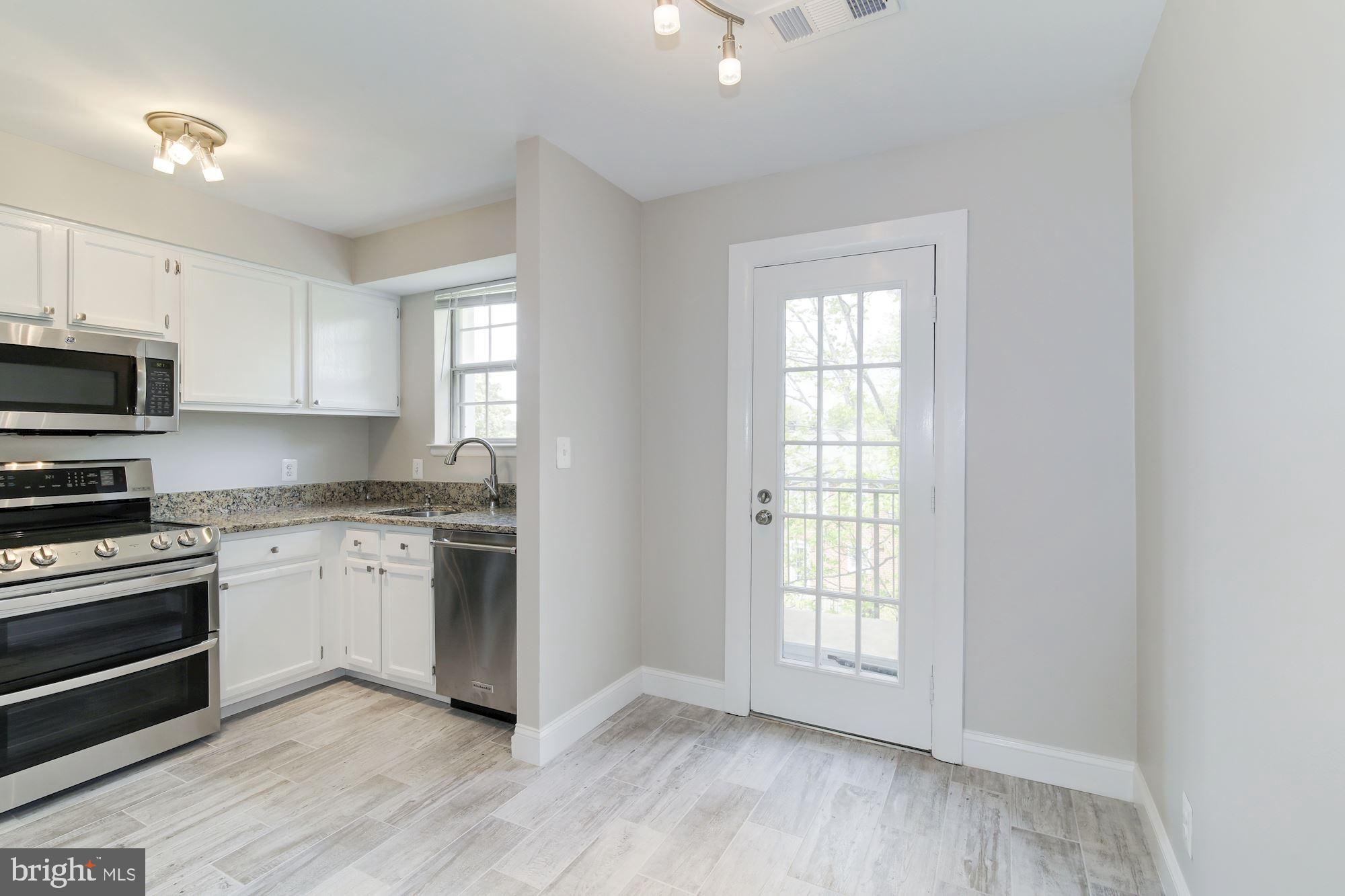 4626 B 28th Road South, Unit B Arlington, VA 22206 - Photo 8 of 22 a kitchen with granite countertop white cabinets and wooden floor