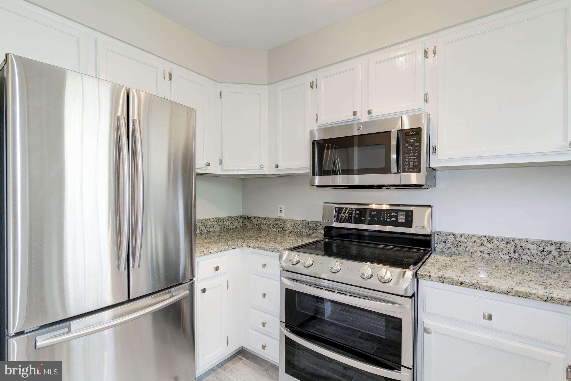 4626 B 28th Road South, Unit B Arlington, VA 22206 - Photo 9 of 22 a kitchen with granite countertop white cabinets and stainless steel appliances