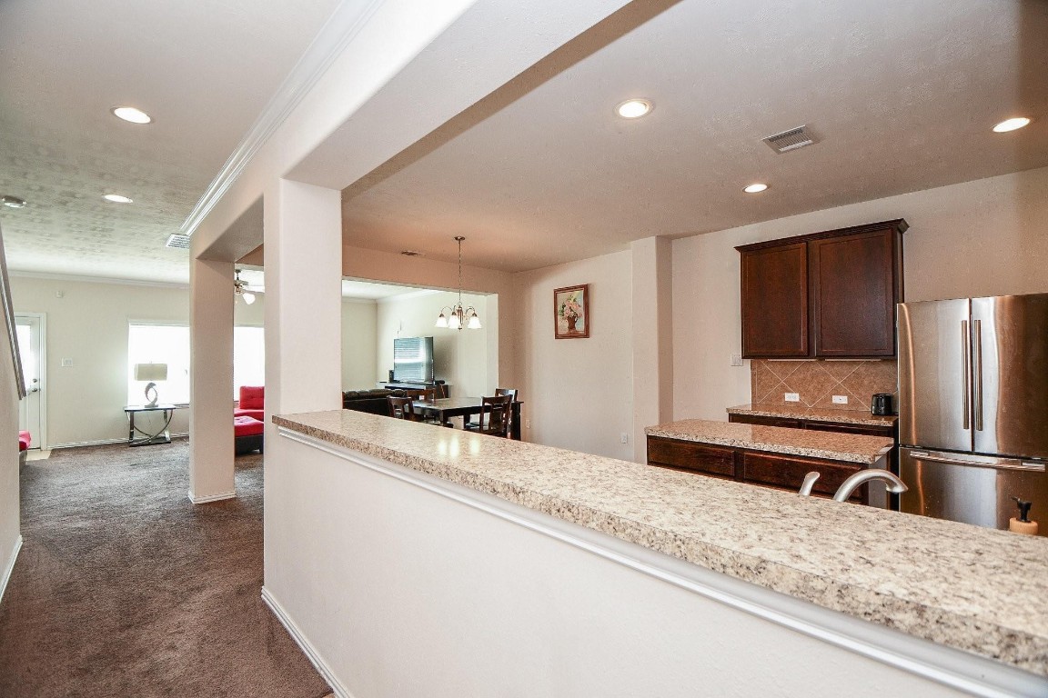 5103 Dartmoor Ridge Trail Houston, TX 77066 - Photo 7 of 47 a kitchen with stainless steel appliances kitchen island granite countertop a refrigerator and a sink