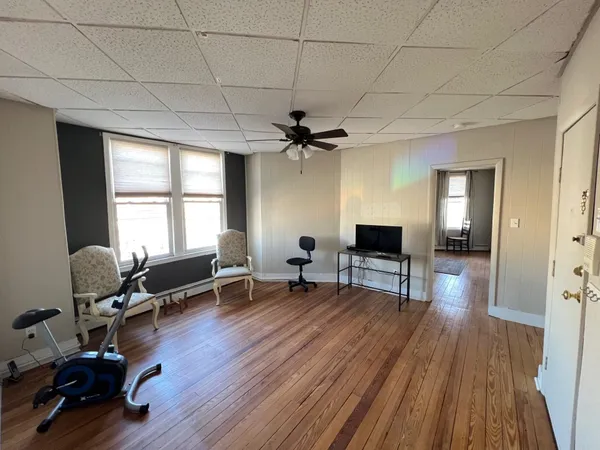 a living room with furniture a window and a wooden floor