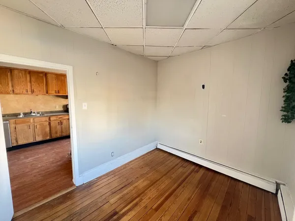 a view of a room with wooden floor and cabinets