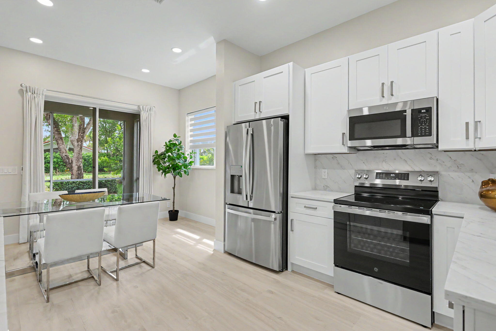 7832 Rockford Road Boynton Beach, FL 33472 - Photo 13 of 40 a kitchen with stainless steel appliances a stove a sink refrigerator and microwave