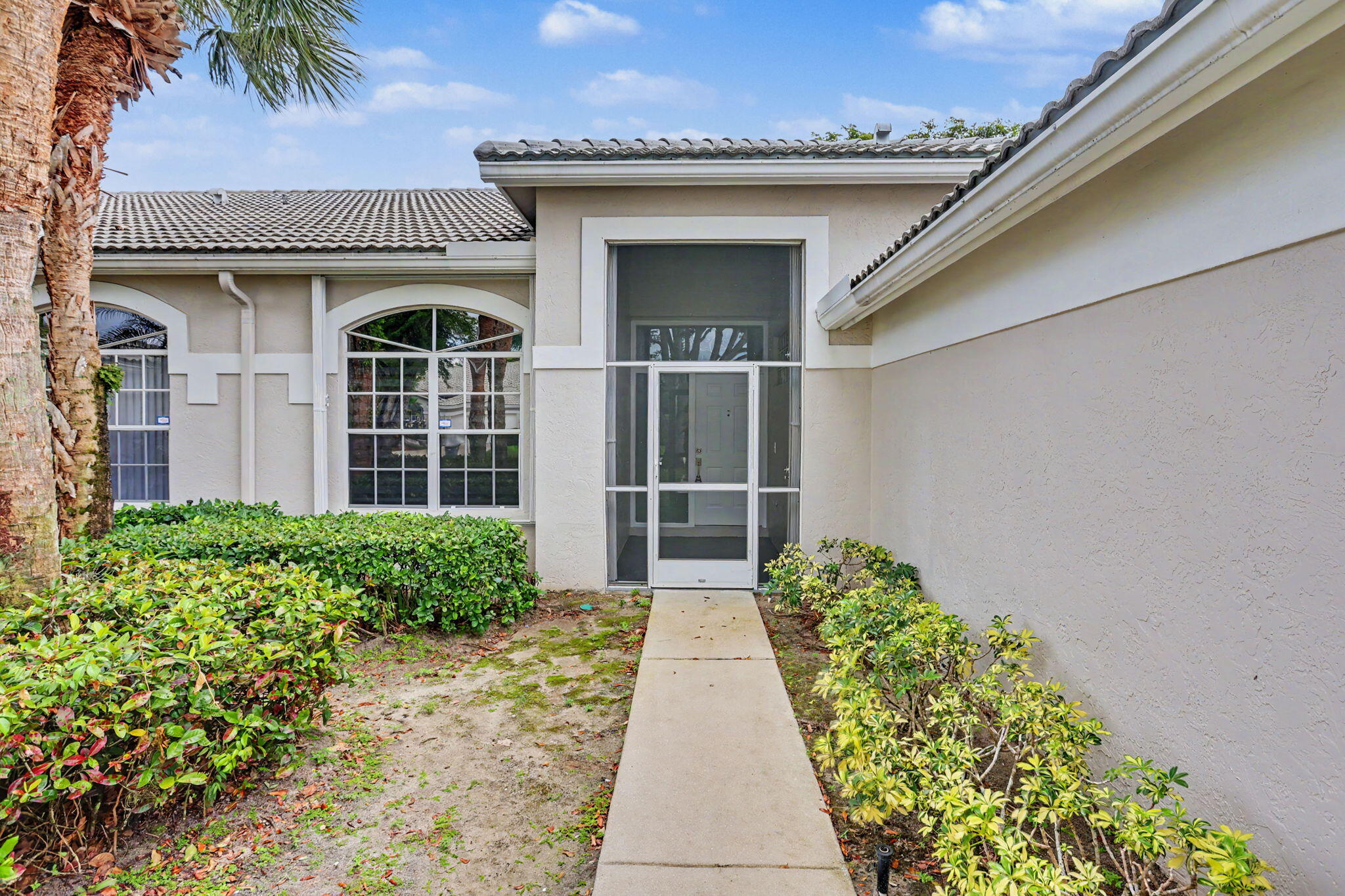7832 Rockford Road Boynton Beach, FL 33472 - Photo 3 of 40 a view of a house with a large window and flower plants