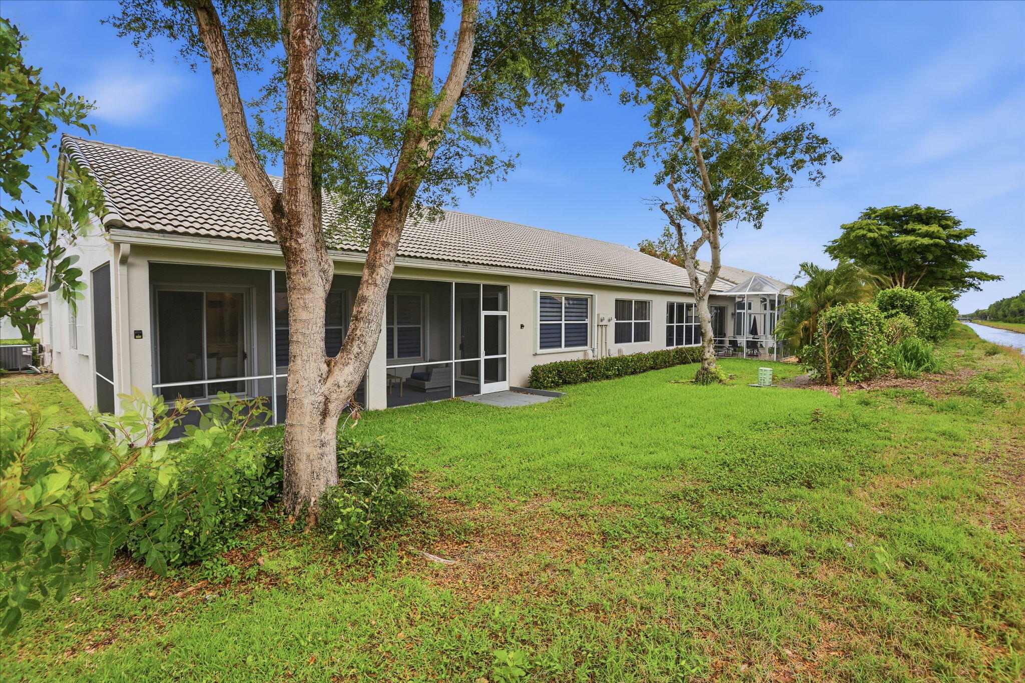 7832 Rockford Road Boynton Beach, FL 33472 - Photo 35 of 40 a tree in front of a house with a garden