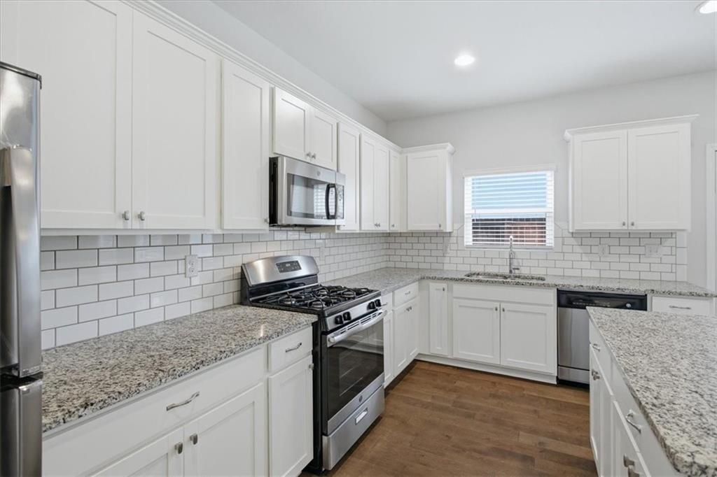 585 Summit Point Canton, GA 30114 - Photo 10 of 30 a kitchen with stainless steel appliances granite countertop a sink stove and cabinets