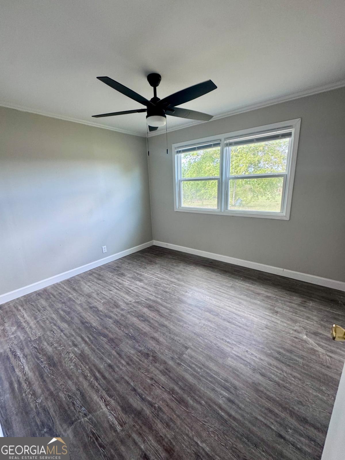 15 Dogwood Road Hazlehurst, GA 31539 - Photo 9 of 16 an empty room with wooden floor fan and windows