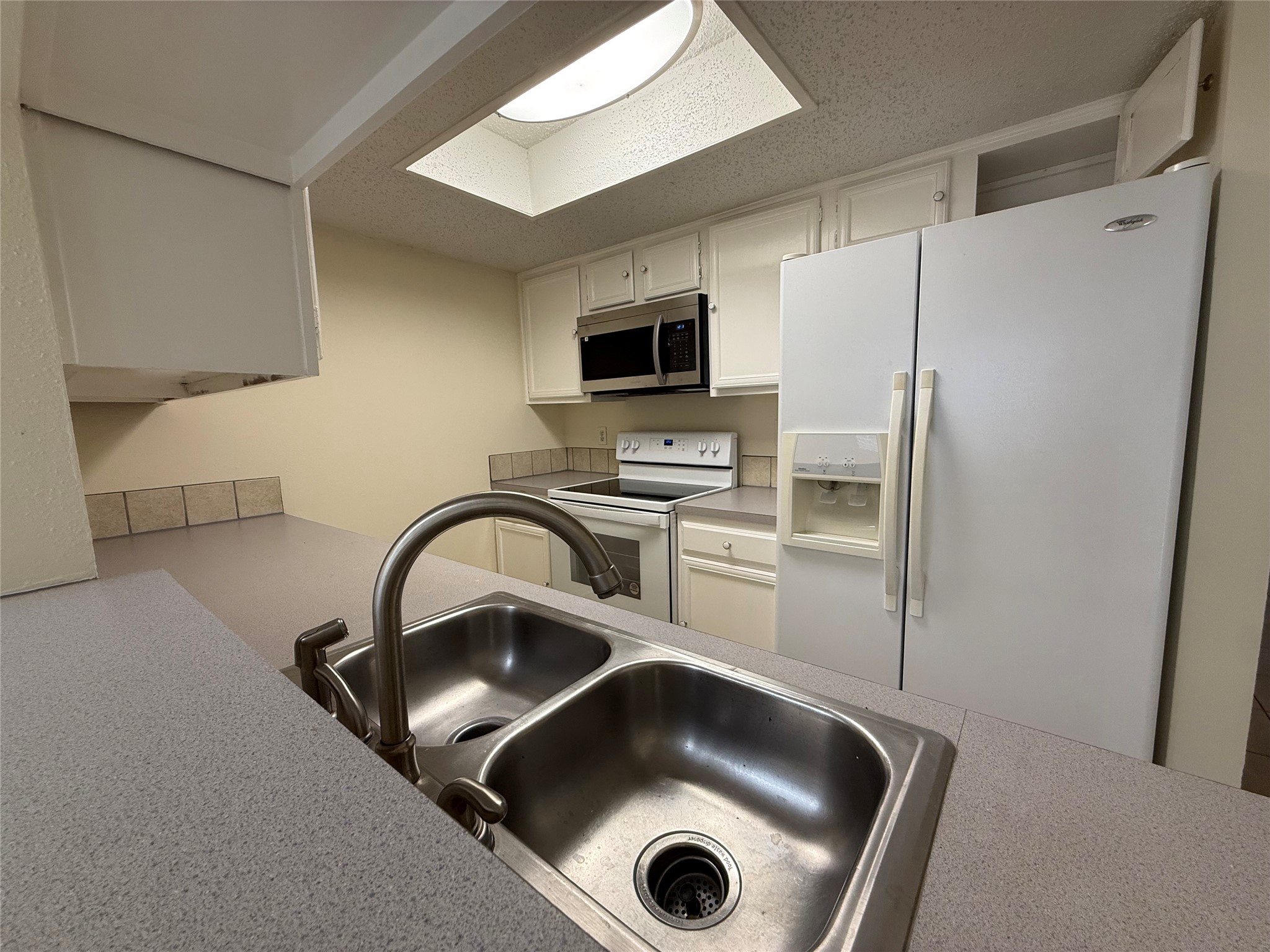 3837 Tanglewilde Street, Unit 3837 Houston, TX 77063 - Photo 2 of 12 a kitchen with a refrigerator and a sink