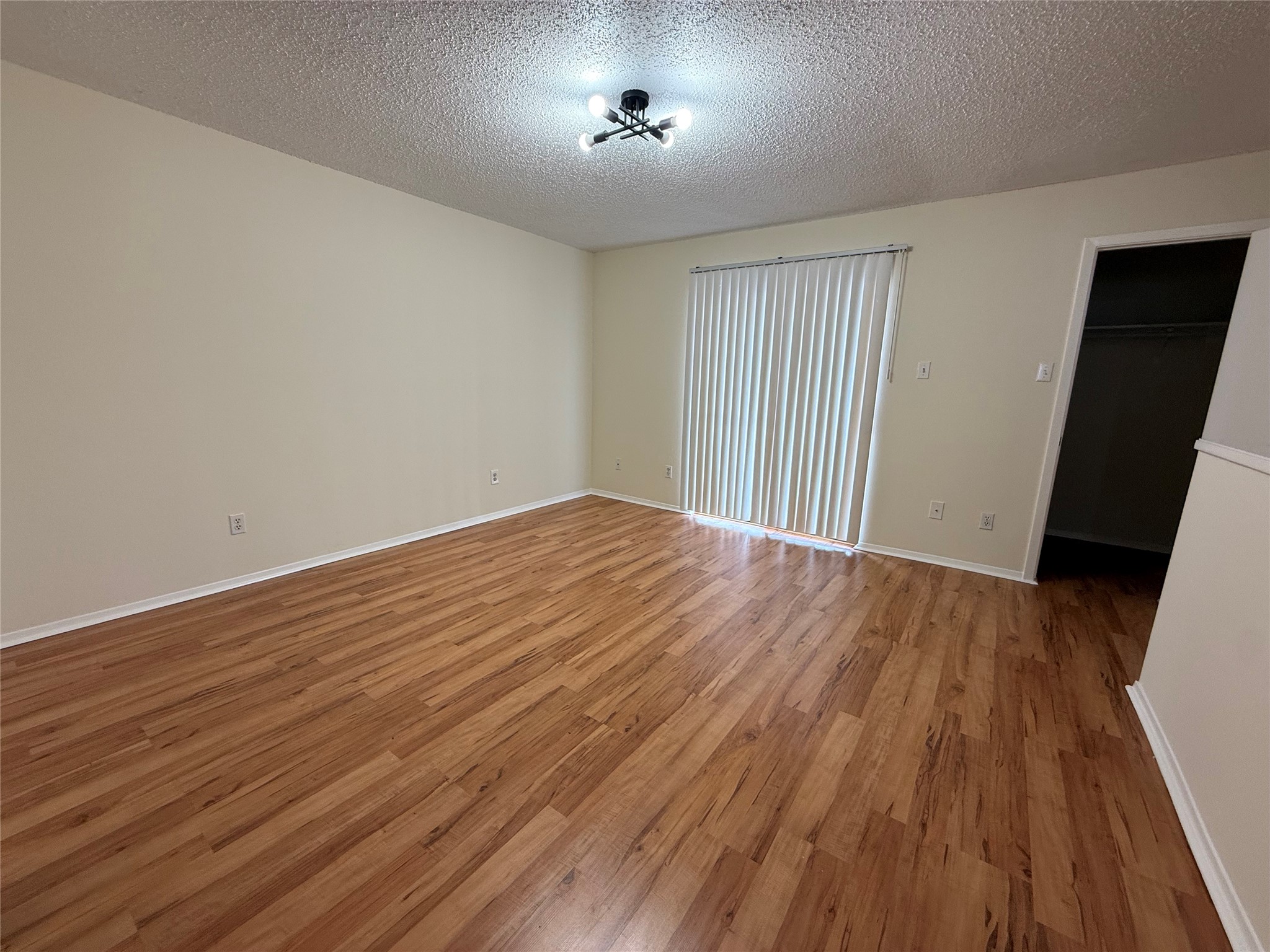 3837 Tanglewilde Street, Unit 3837 Houston, TX 77063 - Photo 6 of 12 wooden floor in an empty room with a window