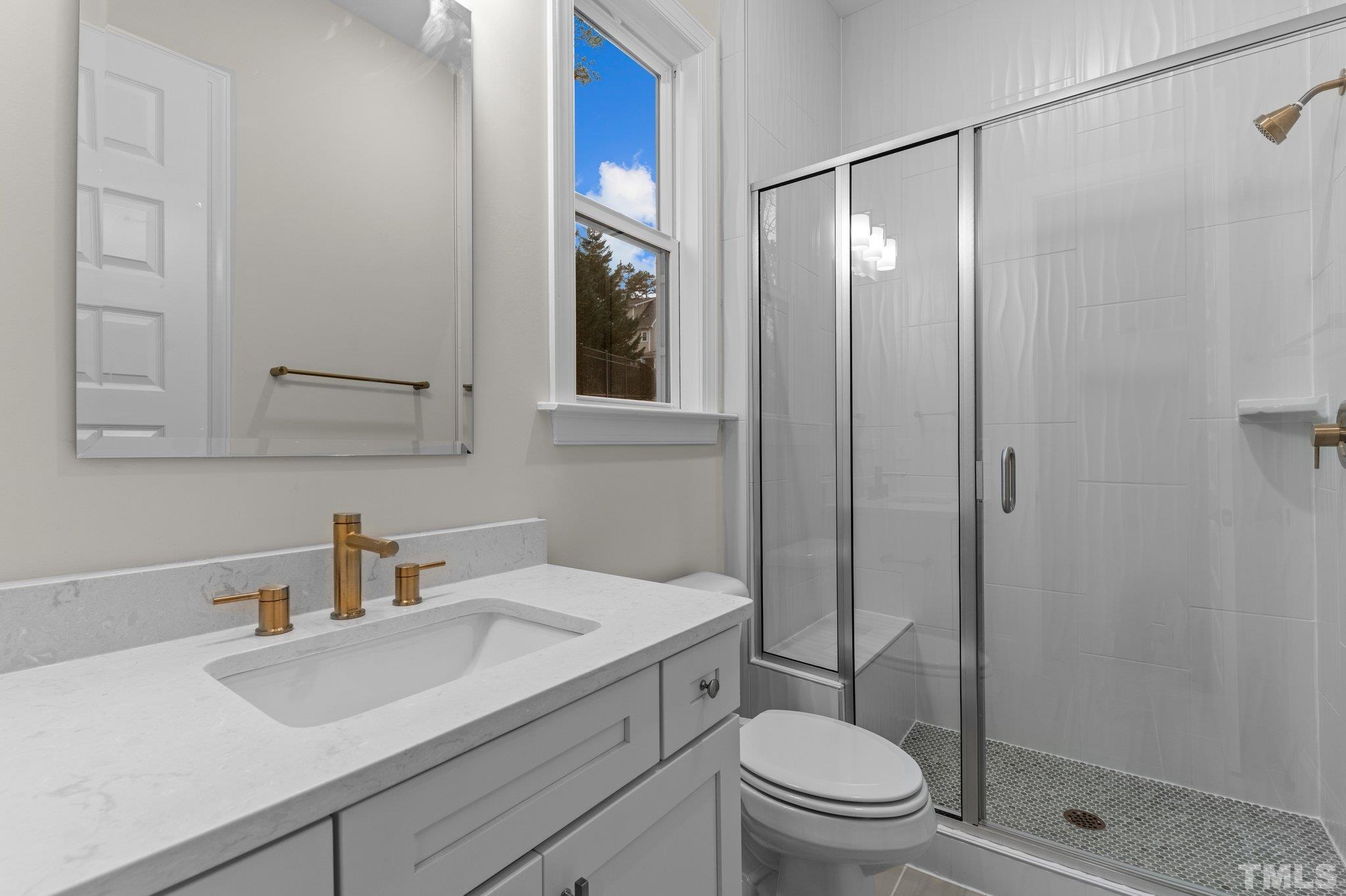 9321 Field Maple Court Raleigh, NC 27613 - Photo 23 of 44 a bathroom with a sink a toilet and shower