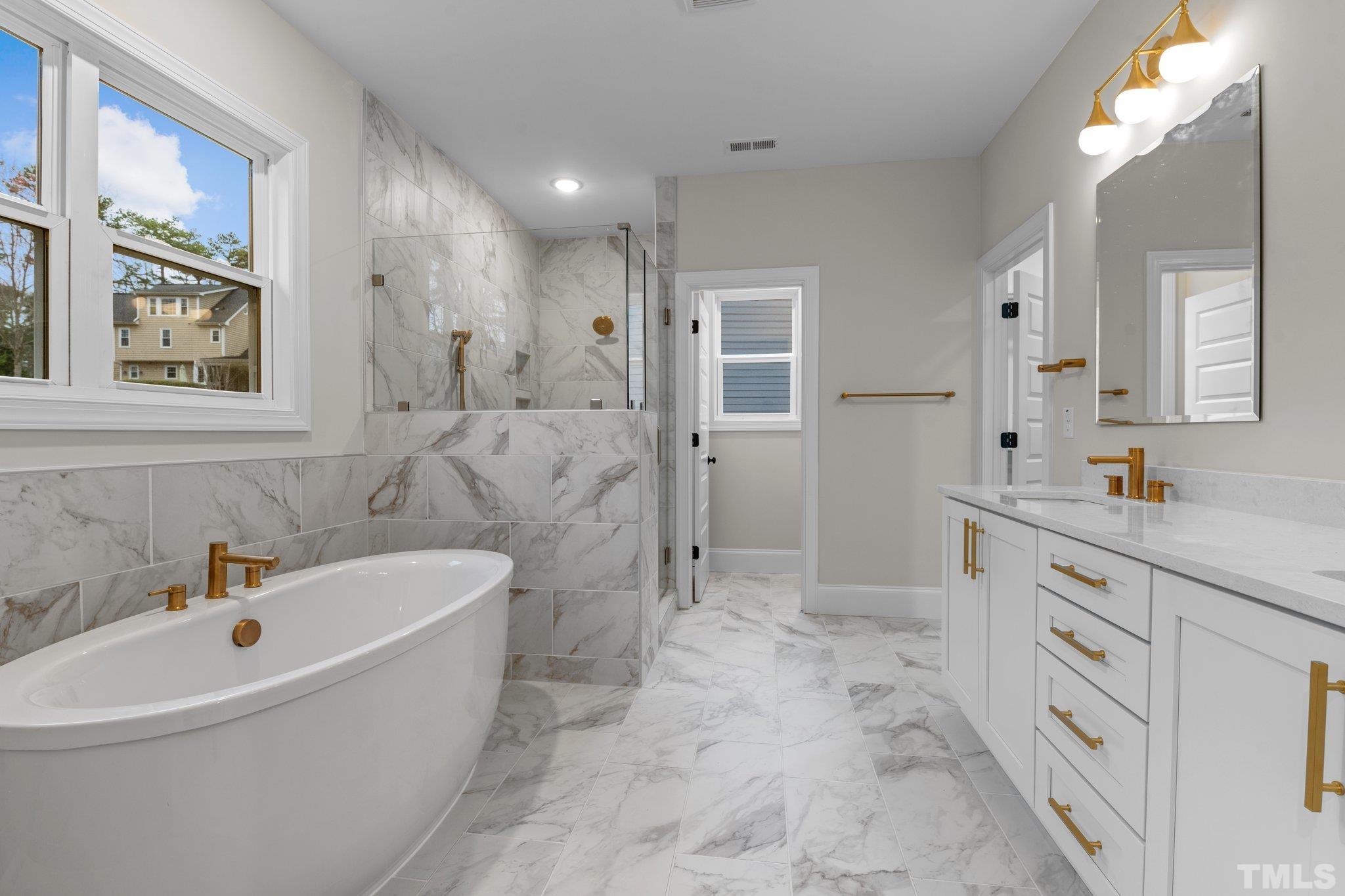 9321 Field Maple Court Raleigh, NC 27613 - Photo 26 of 44 a bathroom with a tub sink and mirror
