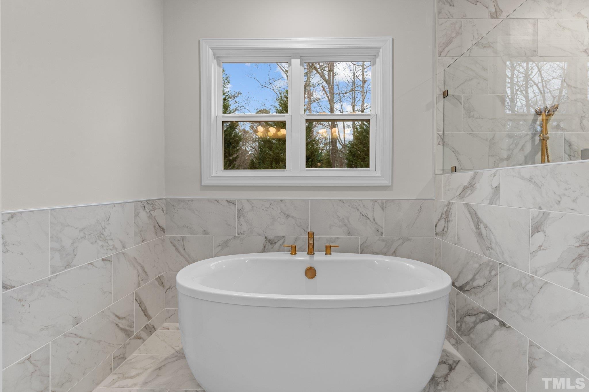 9321 Field Maple Court Raleigh, NC 27613 - Photo 27 of 44 a white bath tub sitting in a bathroom next to a window