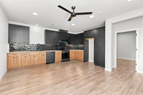 a kitchen with stainless steel appliances kitchen island granite countertop a refrigerator and a stove top oven