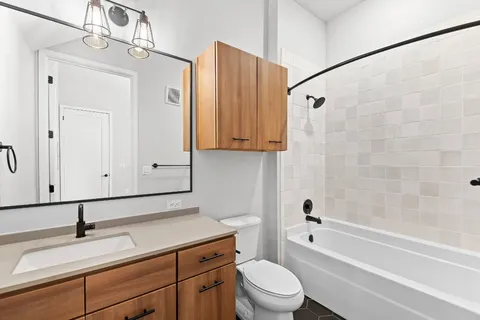 a bathroom with a granite countertop sink a toilet and bathtub