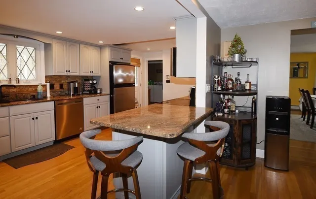 a kitchen with granite countertop a sink a stove and cabinets