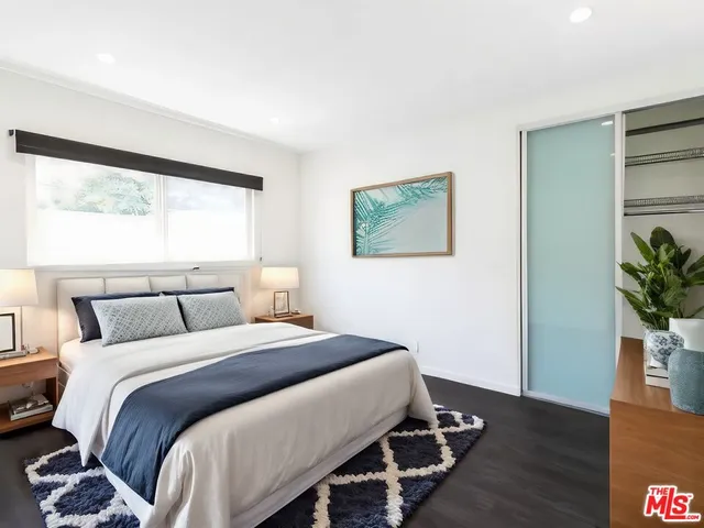 a bedroom with a bed and a potted plant