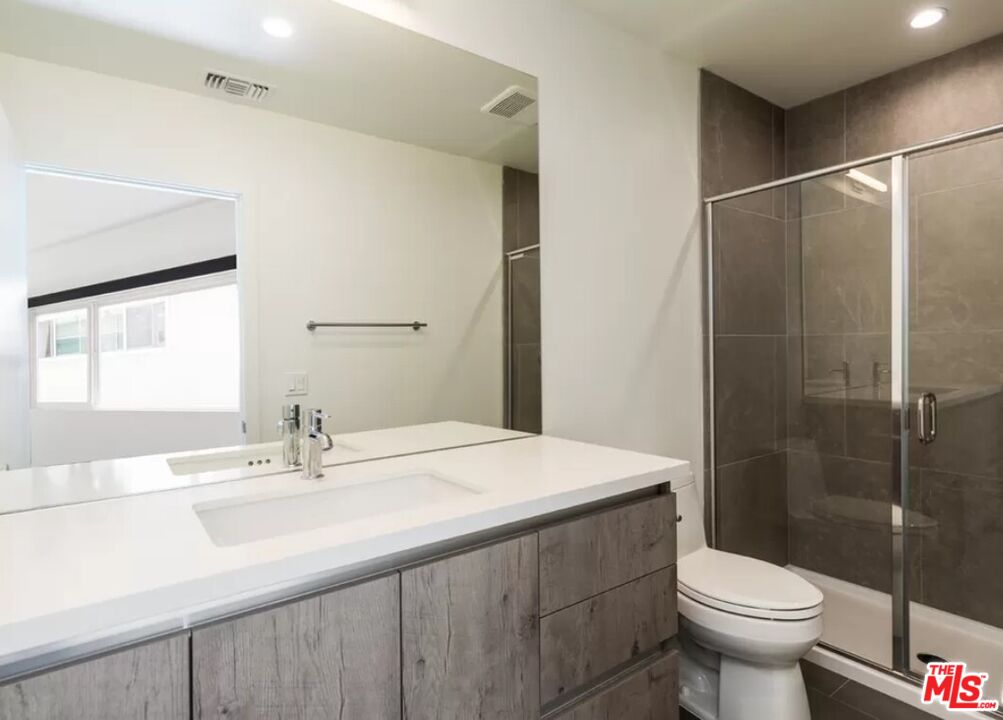 1434 10th Street, Unit 8 Santa Monica, CA 90401 - Photo 7 of 10 a bathroom with a sink toilet and a mirror