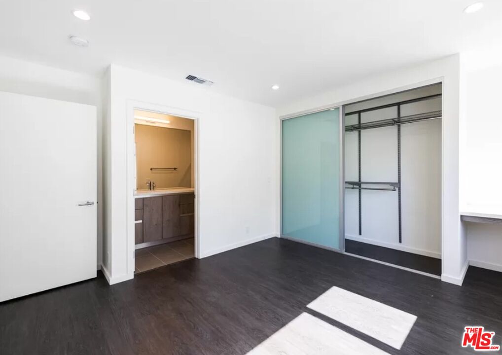 1434 10th Street, Unit 8 Santa Monica, CA 90401 - Photo 8 of 10 a view of an empty room with wooden floor and a window