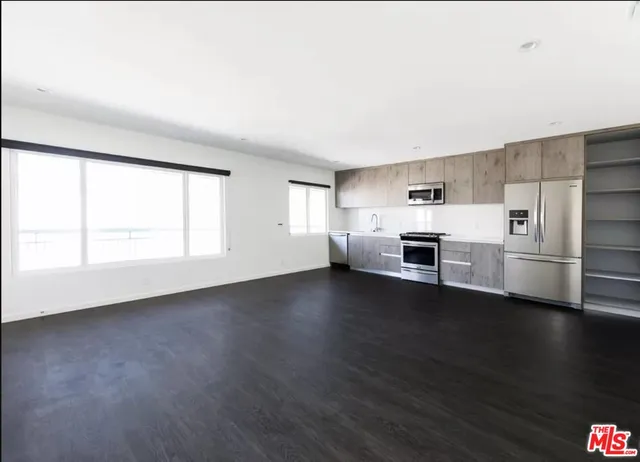 a view of a kitchen with a sink stove cabinets and empty room