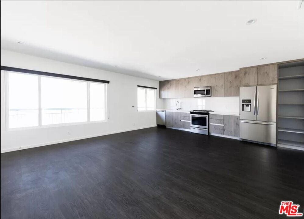 1434 10th Street, Unit 8 Santa Monica, CA 90401 - Photo 10 of 10 a view of a kitchen with a sink stove cabinets and empty room