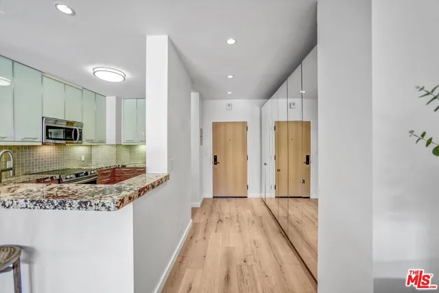 a kitchen with stainless steel appliances granite countertop a sink a stove a microwave cabinets and a counter top space