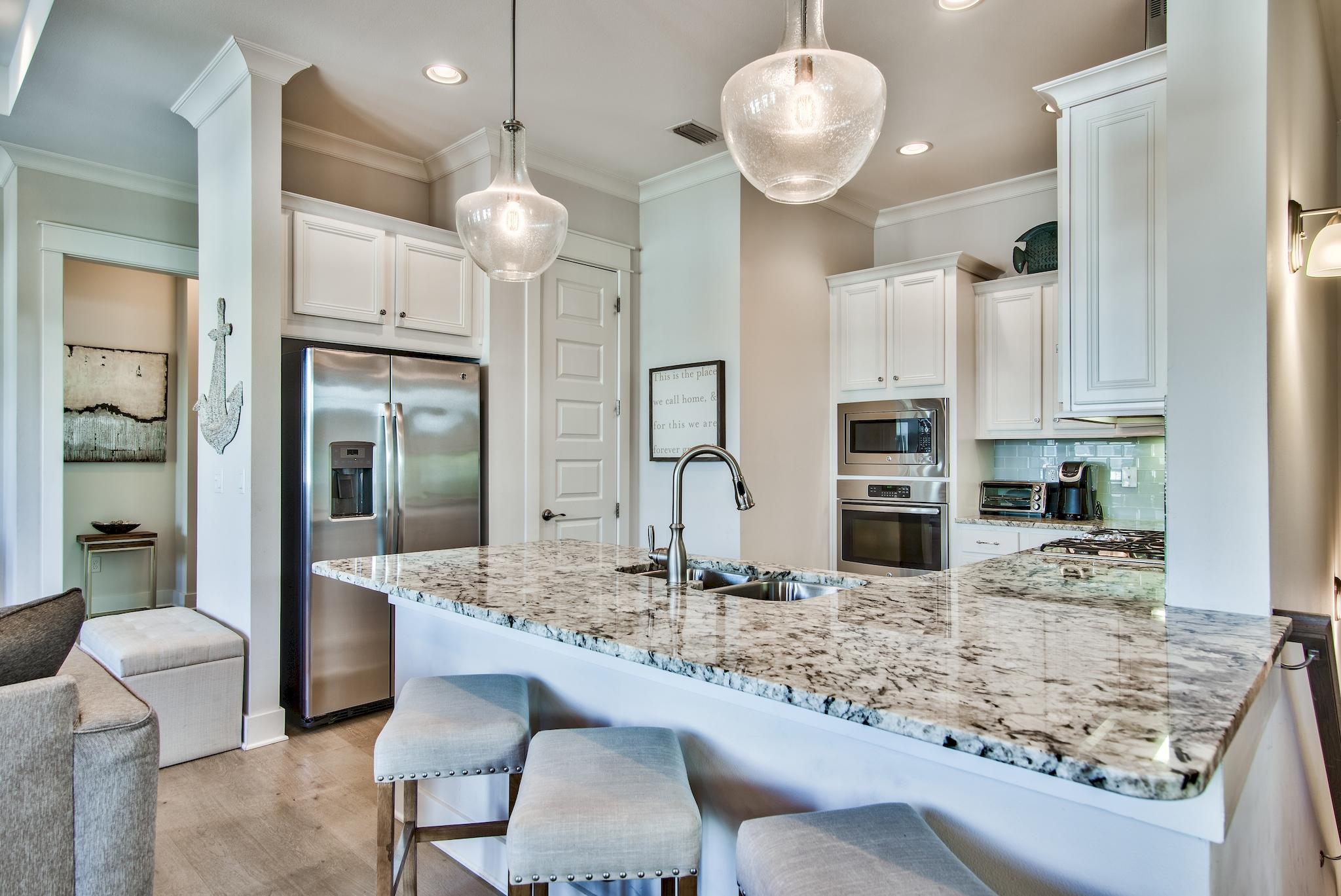 33 Milestone Dr Inlet Beach, Unit C Inlet Beach, FL 32461 - Photo 6 of 24 a kitchen with stainless steel appliances granite countertop a sink refrigerator and cabinets