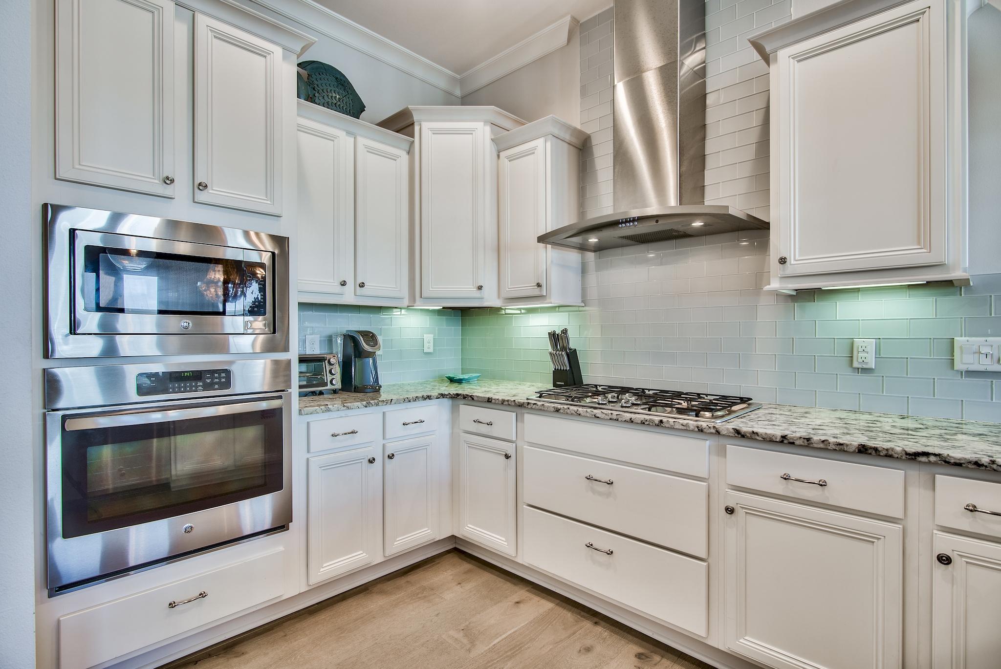 33 Milestone Dr Inlet Beach, Unit C Inlet Beach, FL 32461 - Photo 8 of 24 a kitchen with stainless steel appliances granite countertop a stove a sink and a microwave