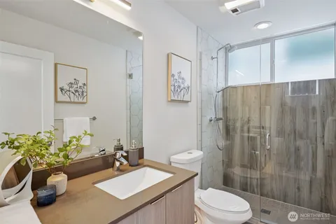 a bathroom with a sink a toilet and shower