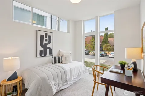 a bedroom with a bed and a table with potted plant