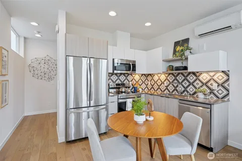 a kitchen with stainless steel appliances granite countertop a sink refrigerator and dining table