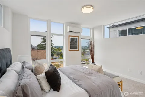 a bedroom with a bed and a large window