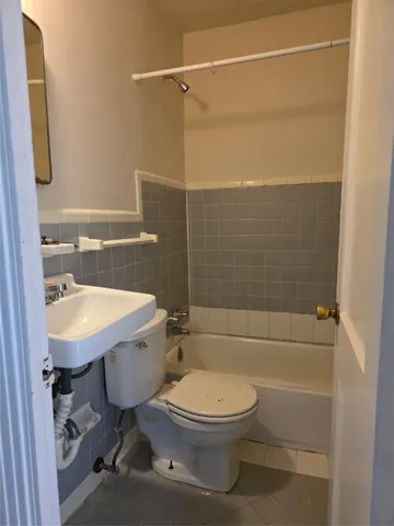 a bathroom with a sink a toilet a mirror and shower