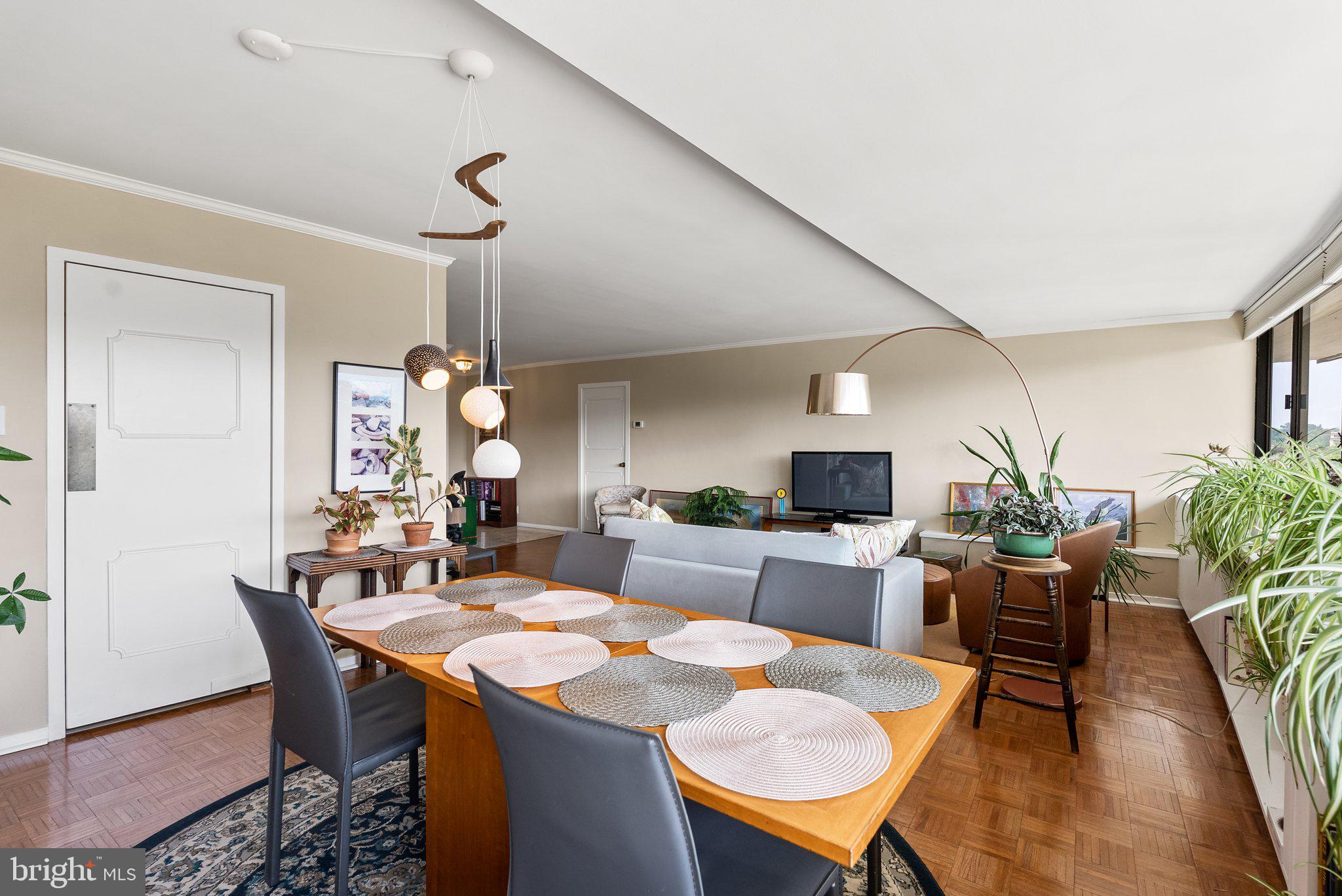 2500 Virginia Avenue Northwest, Unit 906S Washington, DC 20037 - Photo 13 of 39 a dining room with wooden floor a chandelier a wooden table and chairs