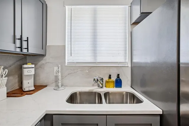 a kitchen with a sink a window and cabinets