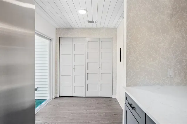a view of an empty room with cabinet and entryway