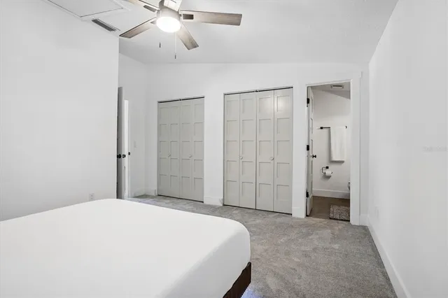 a spacious bedroom with a bed and a chandelier