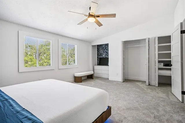 a spacious bedroom with a bed and a chandelier
