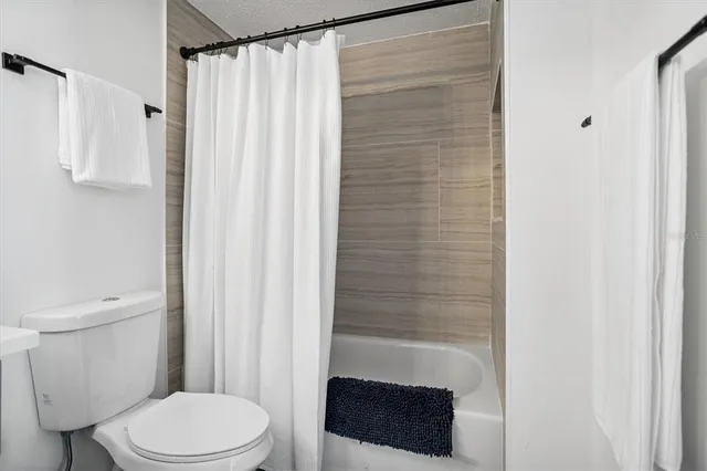 a bathroom with a shower curtain and a toilet