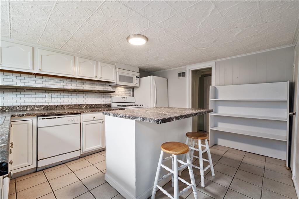 22 Eleanor Street Pittsburgh, PA 15203 - Photo 3 of 36 a kitchen with granite countertop cabinets and chair