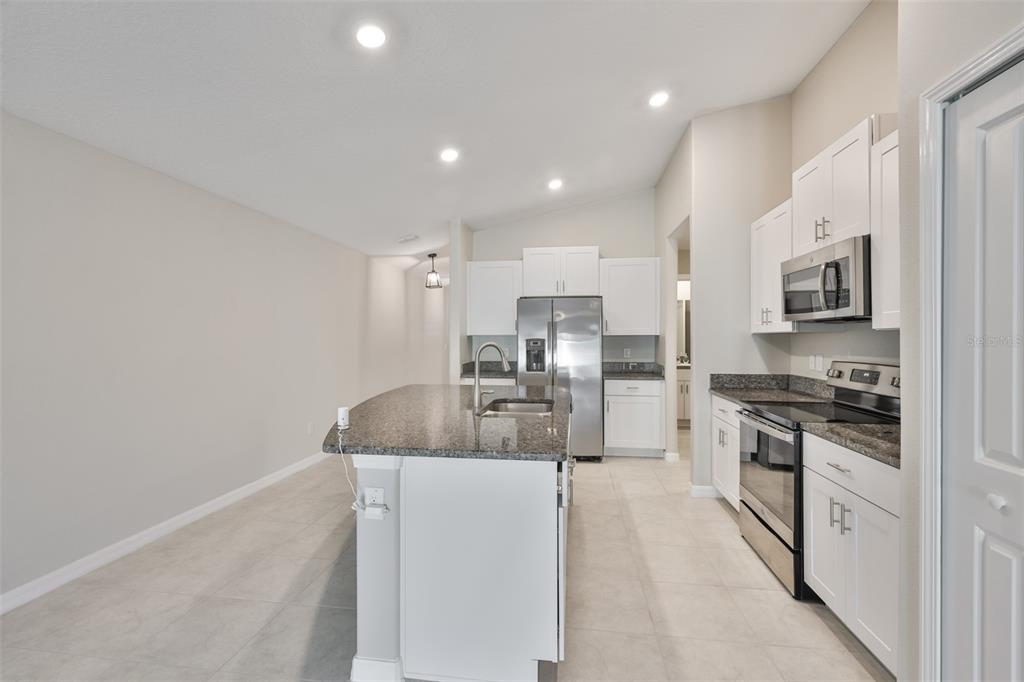 31867 Barrel Wave Way Wesley Chapel, FL 33545 - Photo 14 of 45 a kitchen with stainless steel appliances granite countertop a sink a stove and a refrigerator