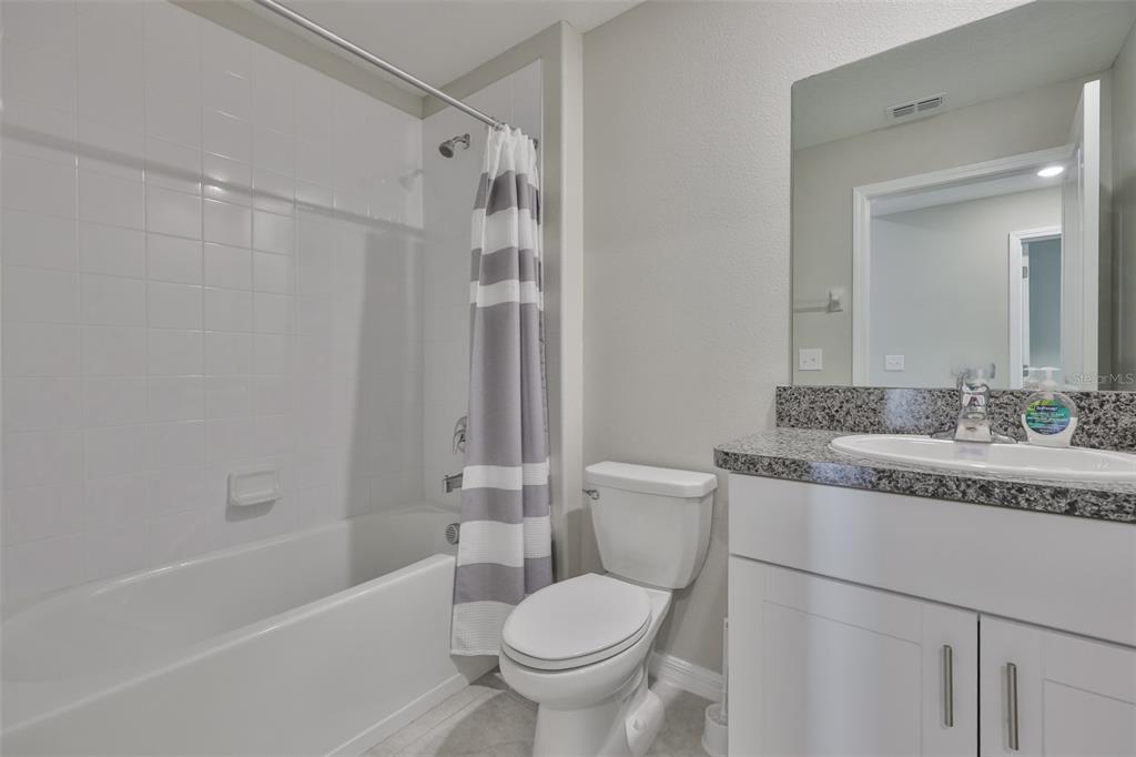 31867 Barrel Wave Way Wesley Chapel, FL 33545 - Photo 17 of 45 a bathroom with a granite countertop sink toilet and shower