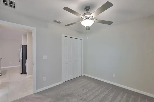 an empty room with a window and a fan