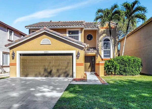 a front view of a house with a yard and garage